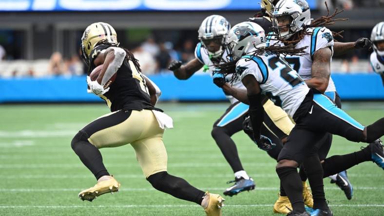 Sep 25, 2022; Charlotte, North Carolina, USA; New Orleans Saints running back Alvin Kamara (41) with the ball as Carolina Panthers cornerback Jaycee Horn (8) and linebacker Shaq Thompson (7) and safety Jeremy Chinn (21) defend in the fourth quarter at Bank of America Stadium. Mandatory Credit: Bob Donnan-USA TODAY Sports