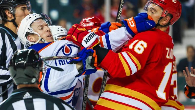 Sep 28, 2022; Calgary, Alberta, CAN; Edmonton Oilers left wing Tyler Benson (16) and Calgary Flames defenseman Nikita Zadorov (16) get into a scrum during the second period at Scotiabank Saddledome. Mandatory Credit: Sergei Belski-USA TODAY Sports