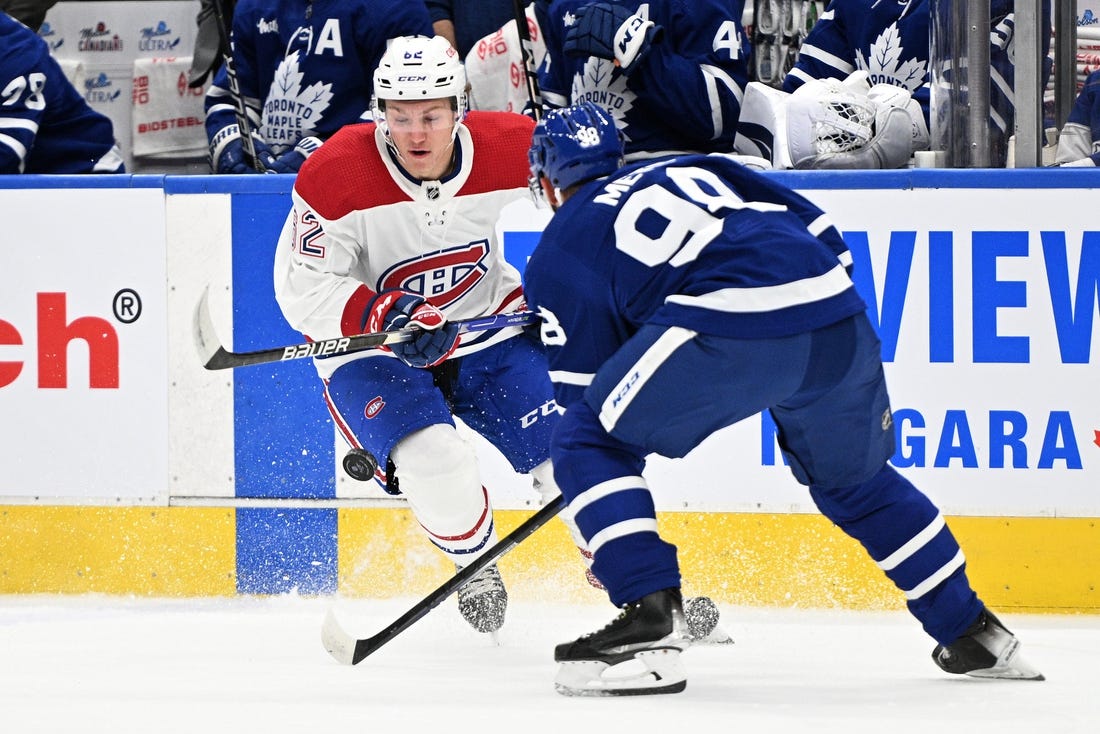 Sep 28, 2022; Toronto, Ontario, CAN; Montreal Canadiens forward Owen Beck (62) battles for the puck with Toronto Maple Leafs defenseman Victor Mete (98) in the first period at Scotiabank Arena. Mandatory Credit: Dan Hamilton-USA TODAY Sports