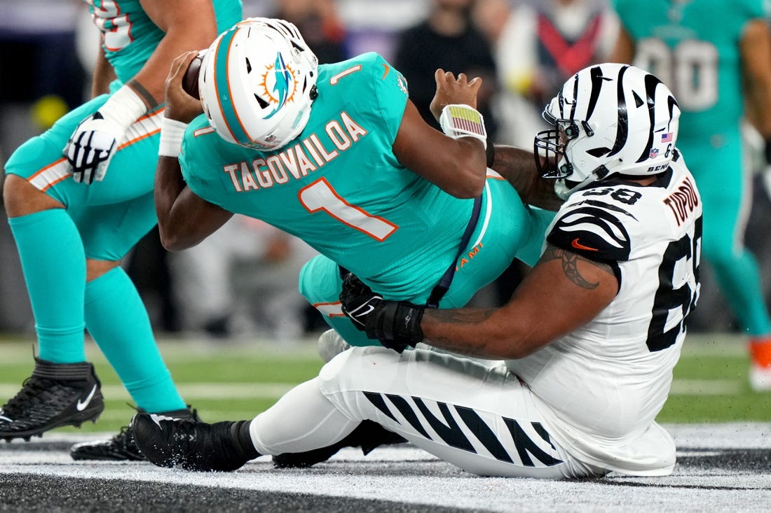 Sep 29, 2022; Cincinnati, Ohio, USA; Cincinnati Bengals defensive tackle Josh Tupou (68) sacks Miami Dolphins quarterback Tua Tagovailoa (1) in the second quarter at Paycor Stadium in Cincinnati. Tagovailoa sustained a head injury on the play and left the game for treatment. Mandatory Credit: Kareem Elgazzar-USA TODAY Sports