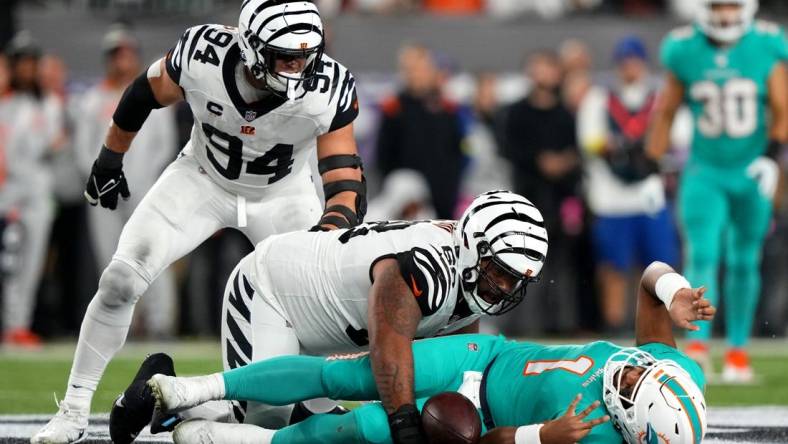 Sep 29, 2022; Cincinnati, Ohio, USA; Cincinnati Bengals defensive tackle Josh Tupou (68) sacks Miami Dolphins quarterback Tua Tagovailoa (1) in the second quarter at Paycor Stadium in Cincinnati. Tagovailoa sustained a head injury on the play and left the game for treatment. Mandatory Credit: Kareem Elgazzar-USA TODAY Sports