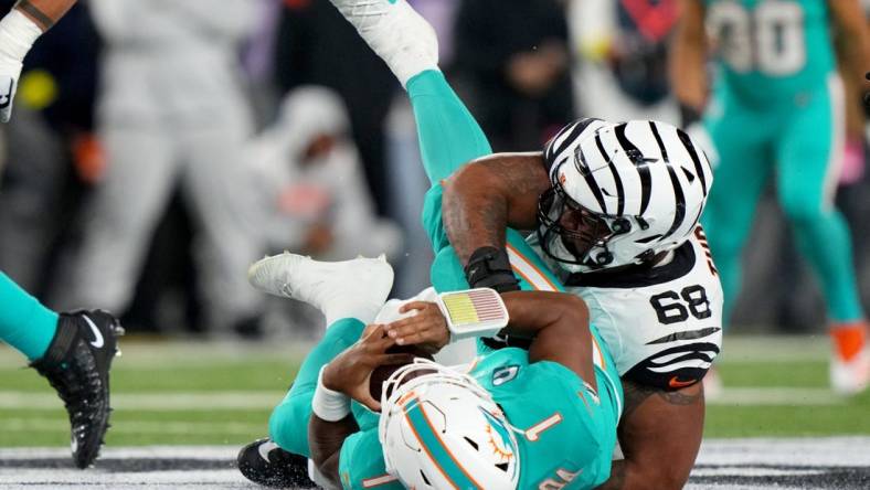 Sep 29, 2022; Cincinnati, Ohio, USA; Cincinnati Bengals defensive tackle Josh Tupou (68) sacks Miami Dolphins quarterback Tua Tagovailoa (1) in the second quarter at Paycor Stadium in Cincinnati. Tagovailoa sustained a head injury on the play and left the game for treatment. Mandatory Credit: Kareem Elgazzar-USA TODAY Sports