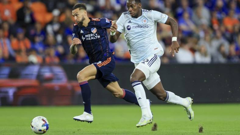 Oct 1, 2022; Cincinnati, Ohio, USA;  FC Cincinnati defender Geoff Cameron (left) chase as Chicago Fire forward Jhon Duran (26) controls the ball in the second half at TQL Stadium. Mandatory Credit: Aaron Doster-USA TODAY Sports