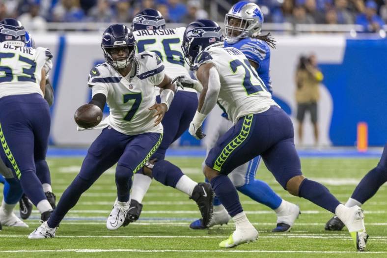 Oct 2, 2022; Detroit, Michigan, USA; Seattle Seahawks quarterback Geno Smith (7) hands off the ball to running back Rashaad Penny (20) against the Detroit Lions during the first quarter at Ford Field. Mandatory Credit: David Reginek-USA TODAY Sports