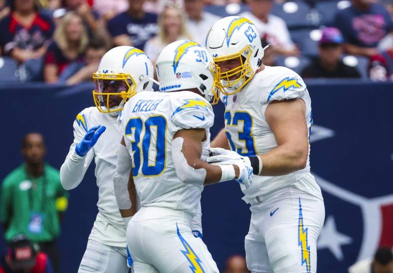 Oct 2, 2022; Houston, Texas, USA;  Los Angeles Chargers running back Austin Ekeler (30) celebrates with Los Angeles Chargers center Corey Linsley (63) after running for a touchdown  during the second quarter against the Houston Texans at NRG Stadium. Mandatory Credit: Kevin Jairaj-USA TODAY Sports
