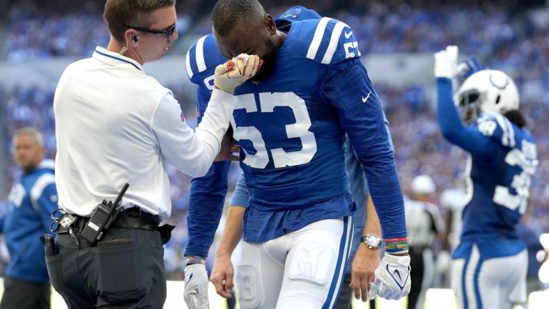 Oct 2, 2022; Indianapolis, Indiana, USA; Indianapolis Colts assistant athletic trainer Kyle Davis tends to linebacker Shaquille Leonard (53) after a play against the Tennessee Titans during the first half at Lucas Oil Stadium. Mandatory Credit: Jenna Watson/IndyStar-USA TODAY NETWORK