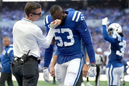 Oct 2, 2022; Indianapolis, Indiana, USA; Indianapolis Colts assistant athletic trainer Kyle Davis tends to linebacker Shaquille Leonard (53) after a play against the Tennessee Titans during the first half at Lucas Oil Stadium. Mandatory Credit: Jenna Watson/IndyStar-USA TODAY NETWORK