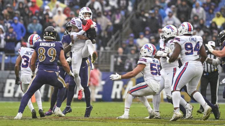 Oct 2, 2022; Baltimore, Maryland, USA;  Buffalo Bills safety Jordan Poyer (21) leaps to secure a Baltimore Ravens quarterback Lamar Jackson (8) tipped pass during the third quarter at M&T Bank Stadium. Mandatory Credit: Tommy Gilligan-USA TODAY Sports