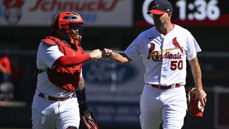 Oct 2, 2022; St. Louis, Missouri, USA;  St. Louis Cardinals catcher Yadier Molina (4) and starting pitcher Adam Wainwright (50) fist bump as they walk in from the bullpen before their record breaking 328th career battery start in a game against the Pittsburgh Pirates at Busch Stadium. Mandatory Credit: Jeff Curry-USA TODAY Sports