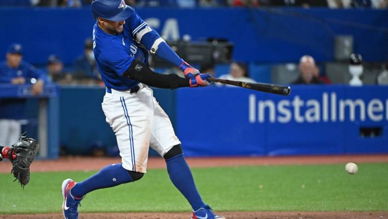 Oct 2, 2022; Toronto, Ontario, CAN; Toronto Blue Jays designated hitter George Springer (4) hits a RBI fielders choice single in the seventh inning against the Boston Red Sox at Rogers Centre. Mandatory Credit: Gerry Angus-USA TODAY Sports