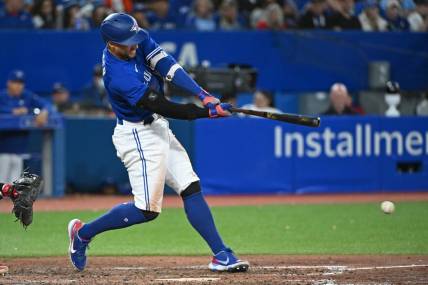 Oct 2, 2022; Toronto, Ontario, CAN; Toronto Blue Jays designated hitter George Springer (4) hits a RBI fielders choice single in the seventh inning against the Boston Red Sox at Rogers Centre. Mandatory Credit: Gerry Angus-USA TODAY Sports