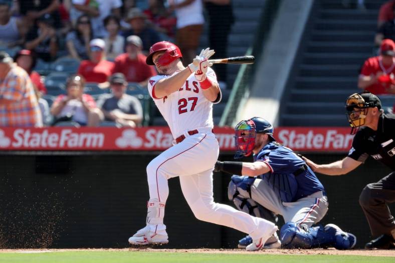Oct 2, 2022; Anaheim, California, USA; Los Angeles Angels center fielder Mike Trout (27) hits a single during the first inning against the Texas Rangers at Angel Stadium. Mandatory Credit: Kiyoshi Mio-USA TODAY Sports