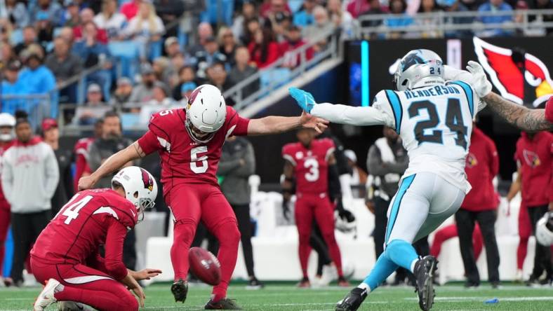 Oct 2, 2022; Charlotte, North Carolina, USA; Arizona Cardinals place kicker Matt Prater (5) kicks a field goal as punter Andy Lee (14) holds and Carolina Panthers cornerback CJ Henderson (24) defends in the fourth quarter at Bank of America Stadium. Mandatory Credit: Bob Donnan-USA TODAY Sports