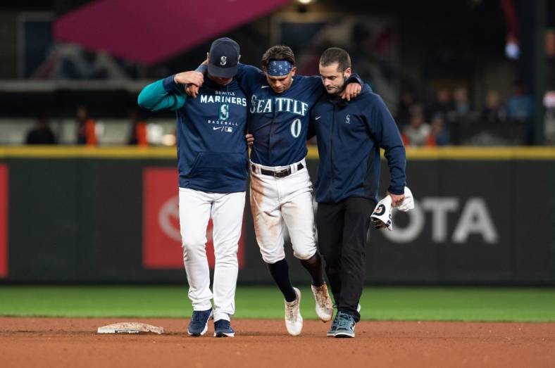 Oct 3, 2022; Seattle, Washington, USA; Seattle Mariners assistant athletic trainer Kevin Orloski and head coach Scott Servais help right fielder Sam Haggerty (0) off the field after Haggerty was injured sliding into second base during the ninth inning against the Detroit Tigers at T-Mobile Park. Detroit defeated Seattle 4-3. Mandatory Credit: Steven Bisig-USA TODAY Sports
