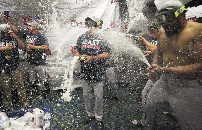 Oct 4, 2022; Miami, Florida, USA; Atlanta Braves manager Brian Snitker, center, and pitcher Kenley Jansen, right, celebrate winning the NL East division with a 2-1 victory over the Miami Marlins at loanDepot Park. Mandatory Credit: Jim Rassol-USA TODAY Sports