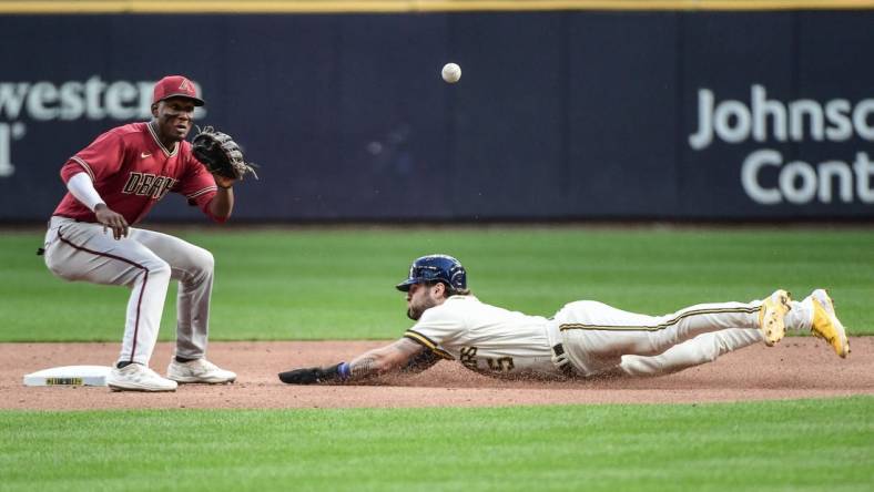 Oct 5, 2022; Milwaukee, Wisconsin, USA;  Milwaukee Brewers center fielder Garrett Mitchell (5) steals second base as Arizona Diamondbacks shortstop Geraldo Perdomo (2) waits for the ball in the second inning at American Family Field. Mandatory Credit: Benny Sieu-USA TODAY Sports