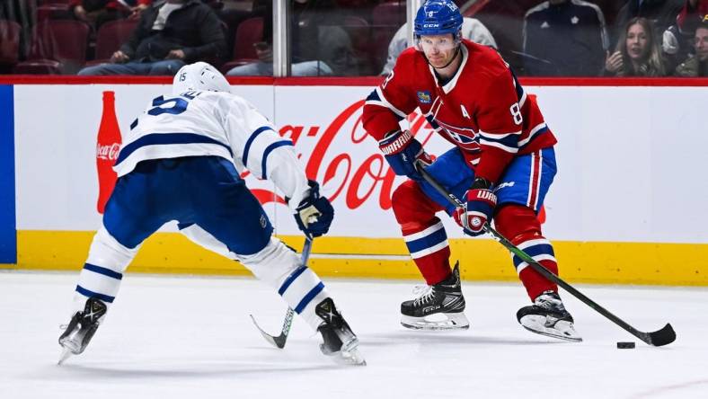 Oct 3, 2022; Montreal, Quebec, CAN; Montreal Canadiens defenseman Mike Matheson (8) plays the puck against Toronto Maple Leafs center Alexander Kerfoot (15) during the third period at Bell Centre. Mandatory Credit: David Kirouac-USA TODAY Sports