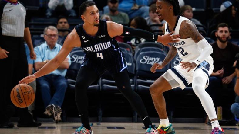 Oct 3, 2022; Memphis, Tennessee, USA; Orlando Magic guard Jalen Suggs (4) dribbles as Memphis Grizzlies guard Ja Morant (12) defends during the second half at FedExForum. Mandatory Credit: Petre Thomas-USA TODAY Sports