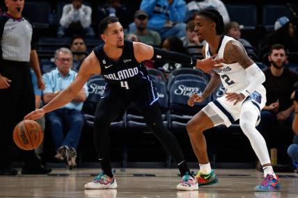 Oct 3, 2022; Memphis, Tennessee, USA; Orlando Magic guard Jalen Suggs (4) dribbles as Memphis Grizzlies guard Ja Morant (12) defends during the second half at FedExForum. Mandatory Credit: Petre Thomas-USA TODAY Sports