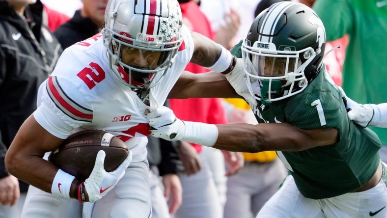Oct 8, 2022; East Lansing, Michigan, USA; Ohio State Buckeyes wide receiver Emeka Egbuka (2) gets tackled by Michigan State Spartans safety Jaden Mangham (1) after a catch in the first quarter of the NCAA Division I football game between the Ohio State Buckeyes and Michigan State Spartans at Spartan Stadium.

Osu22msu Kwr 22
