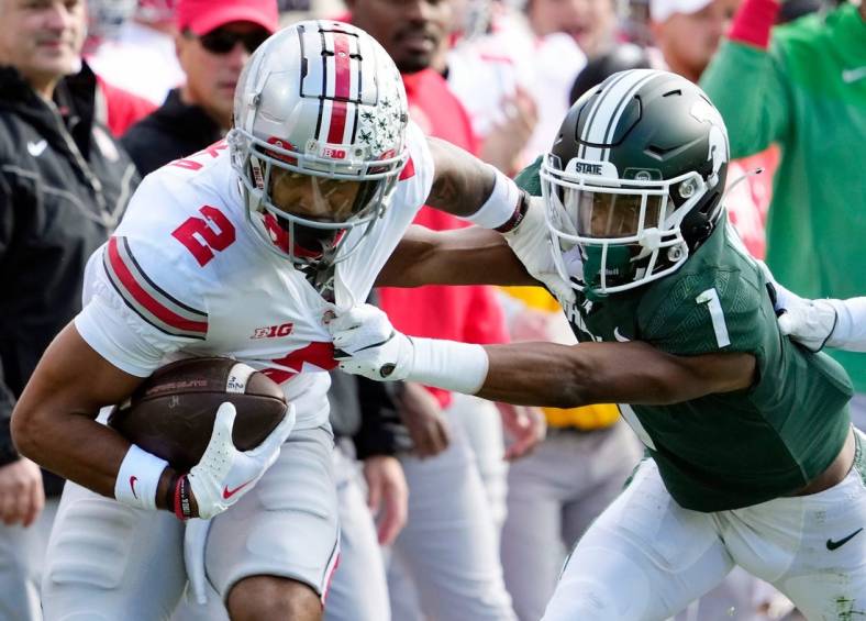 Oct 8, 2022; East Lansing, Michigan, USA; Ohio State Buckeyes wide receiver Emeka Egbuka (2) gets tackled by Michigan State Spartans safety Jaden Mangham (1) after a catch in the first quarter of the NCAA Division I football game between the Ohio State Buckeyes and Michigan State Spartans at Spartan Stadium.

Osu22msu Kwr 22