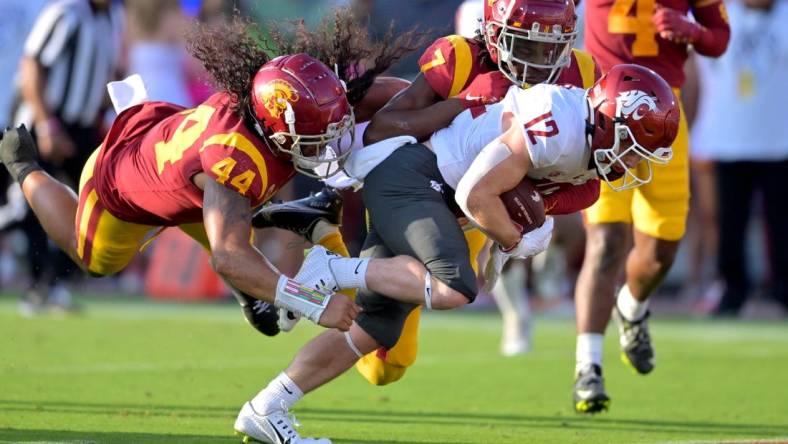 Oct 8, 2022; Los Angeles, California, USA;  Washington State Cougars wide receiver Robert Ferrel (12) drags USC Trojans linebacker Tuasivi Nomura (44) and defensive back Calen Bullock (7) into the end zone for a touchdown in the first half at United Airlines Field at Los Angeles Memorial Coliseum. Mandatory Credit: Jayne Kamin-Oncea-USA TODAY Sports