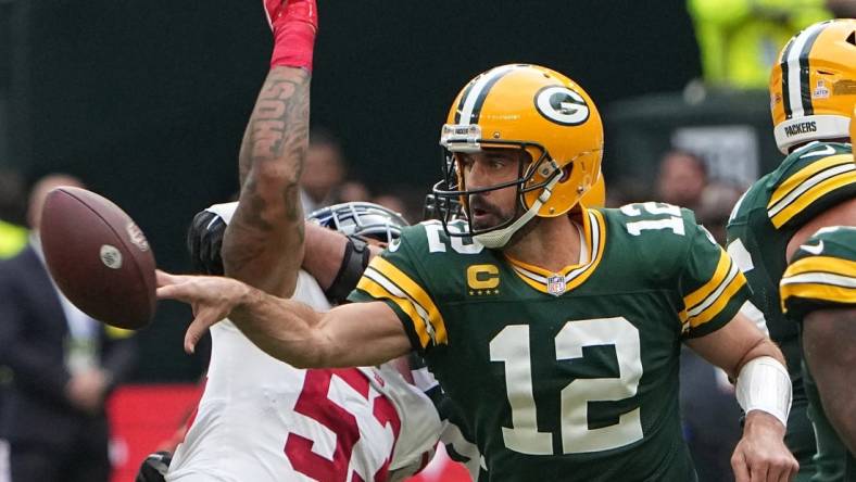 Oct 9, 2022; Tottenham, ENG;  Green Bay Packers quarterback Aaron Rodgers (12) flips the ball to tight end Robert Tonyan during the second quarter of their game against the New York Giants at Tottenham Hotspur Stadium. Mandatory Credit: Mark Hoffman-USA TODAY Sports