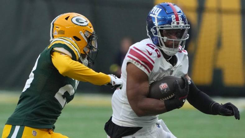 Oct 9, 2022; London, United Kingdom; New York Giants running back Saquon Barkley (26) carries the ball against Green Bay Packers cornerback Jaire Alexander (23) in the first half during an NFL International Series game at Tottenham Hotspur Stadium. Mandatory Credit: Kirby Lee-USA TODAY Sports