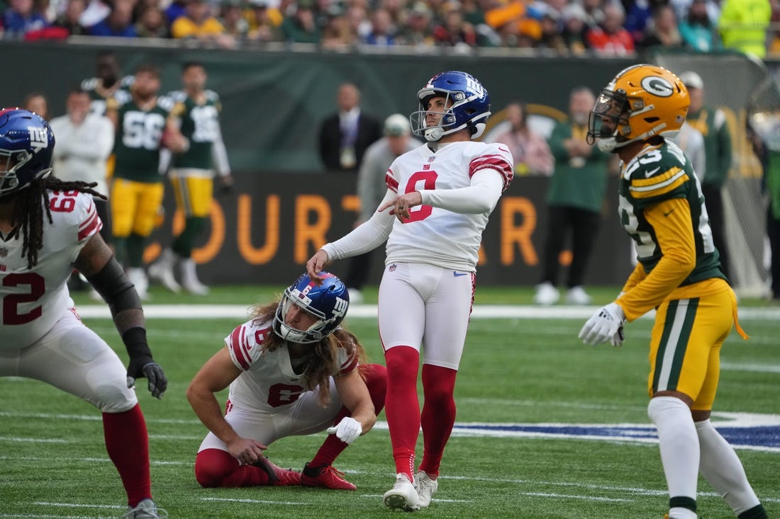 Oct 9, 2022; London, United Kingdom; New York Giants place kicker Graham Gano (9) kicks a field goal out of the hold of punter Jamie Gillan (6) in the first half against the Green Bay Packers during an NFL International Series game at Tottenham Hotspur Stadium. Mandatory Credit: Kirby Lee-USA TODAY Sports