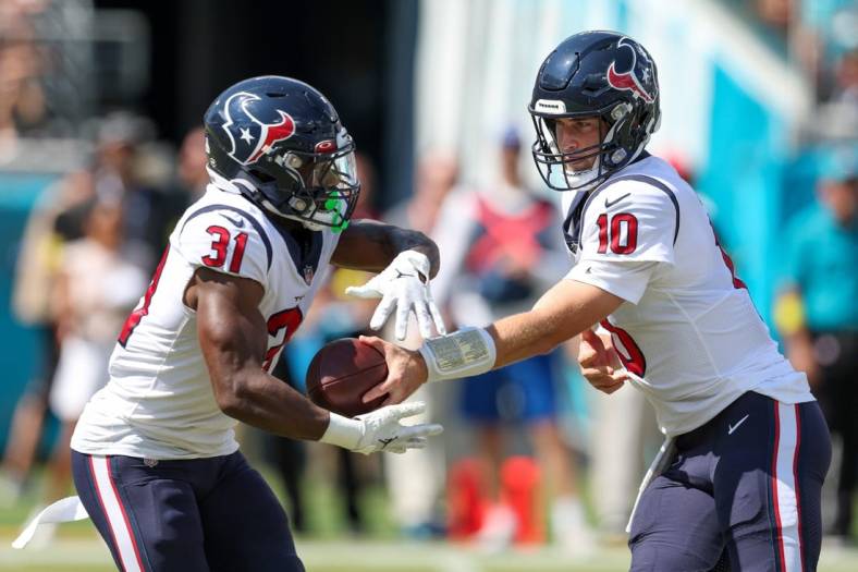 Oct 9, 2022; Jacksonville, Florida, USA;  Houston Texans quarterback Davis Mills (10) hands off to Houston Texans running back Dameon Pierce (31) against the Jacksonville Jaguars in the first quarter at TIAA Bank Field. Mandatory Credit: Nathan Ray Seebeck-USA TODAY Sports