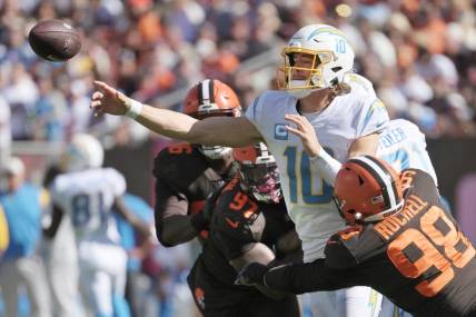 Oct 9, 2022; Cleveland, Ohio, USA; Los Angeles Chargers quarterback Justin Herbert (10) throws a pass as Cleveland Browns defensive end Isaac Rochell (98) and defensive tackle Perrion Winfrey (97) defend during the first half at FirstEnergy Stadium. Mandatory Credit: Ken Blaze-USA TODAY Sports