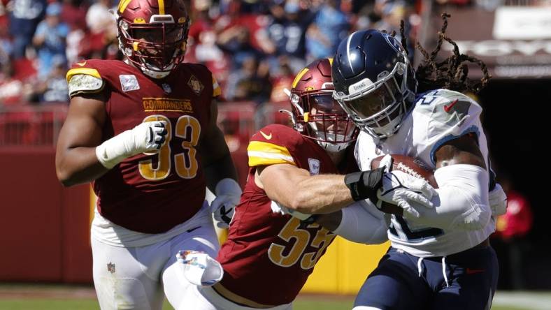 Oct 9, 2022; Landover, Maryland, USA; Tennessee Titans running back Derrick Henry (22) carries the ball as Washington Commanders linebacker Cole Holcomb (55) makes the tackle during the first quarter at FedExField. Mandatory Credit: Geoff Burke-USA TODAY Sports