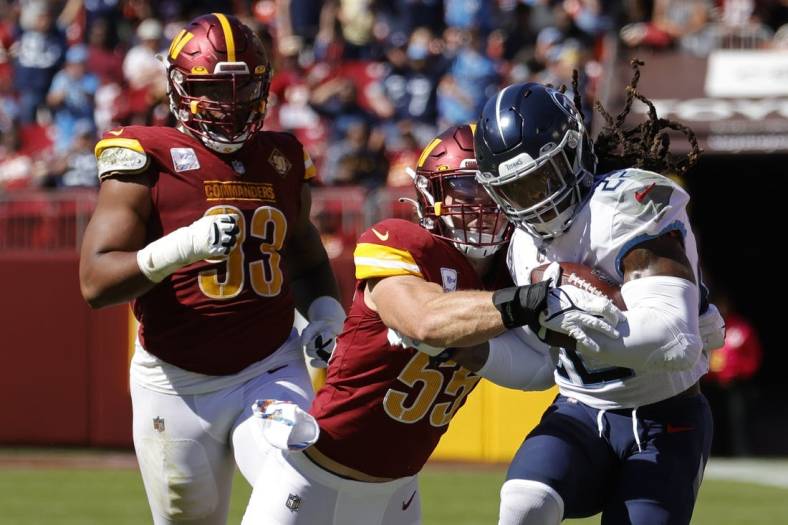 Oct 9, 2022; Landover, Maryland, USA; Tennessee Titans running back Derrick Henry (22) carries the ball as Washington Commanders linebacker Cole Holcomb (55) makes the tackle during the first quarter at FedExField. Mandatory Credit: Geoff Burke-USA TODAY Sports