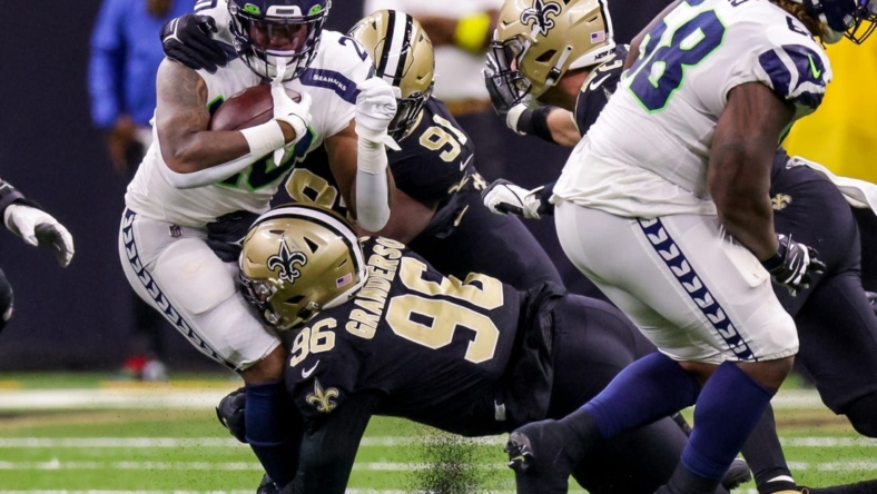 Oct 9, 2022; New Orleans, Louisiana, USA; Seattle Seahawks running back Rashaad Penny (20) is tackled by New Orleans Saints defensive end Carl Granderson (96) and defensive tackle Kentavius Street (91) during the first half at Caesars Superdome. Mandatory Credit: Stephen Lew-USA TODAY Sports