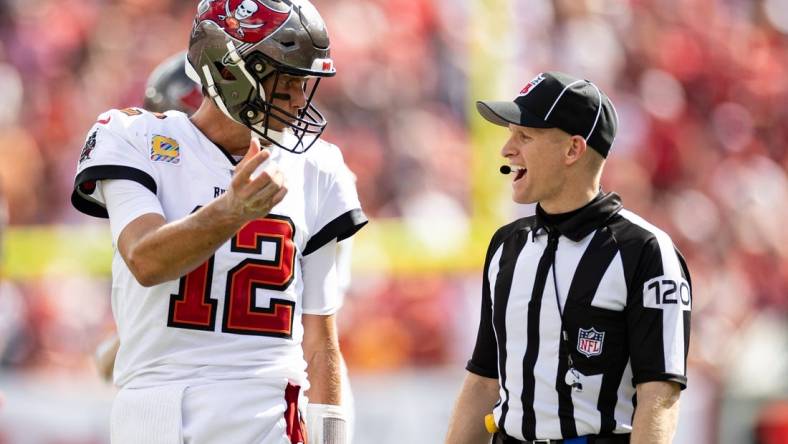 Oct 9, 2022; Tampa, Florida, USA; Tampa Bay Buccaneers quarterback Tom Brady (12) discusses a call with side judge Jonah Monroe (120) during the second half against the Atlanta Falcons at Raymond James Stadium. Mandatory Credit: Matt Pendleton-USA TODAY Sports