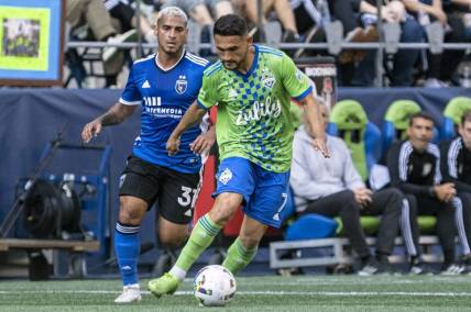 Oct 9, 2022; Seattle, Washington, USA; Seattle Sounders FC midfielder Cristian Roldan (7) dribbles the ball against San Jose Earthquakes defender Miguel Trauco (31) during the first half at Lumen Field. Mandatory Credit: Stephen Brashear-USA TODAY Sports