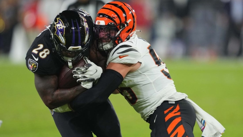 Oct 9, 2022; Baltimore, Maryland, USA; Baltimore Ravens running back Mike Davis (28) gains yards in the second quarter defended by Cincinnati Bengals linebacker Logan Wilson (55) at M&T Bank Stadium. Mandatory Credit: Mitch Stringer-USA TODAY Sports