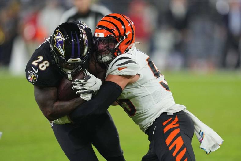 Oct 9, 2022; Baltimore, Maryland, USA; Baltimore Ravens running back Mike Davis (28) gains yards in the second quarter defended by Cincinnati Bengals linebacker Logan Wilson (55) at M&T Bank Stadium. Mandatory Credit: Mitch Stringer-USA TODAY Sports