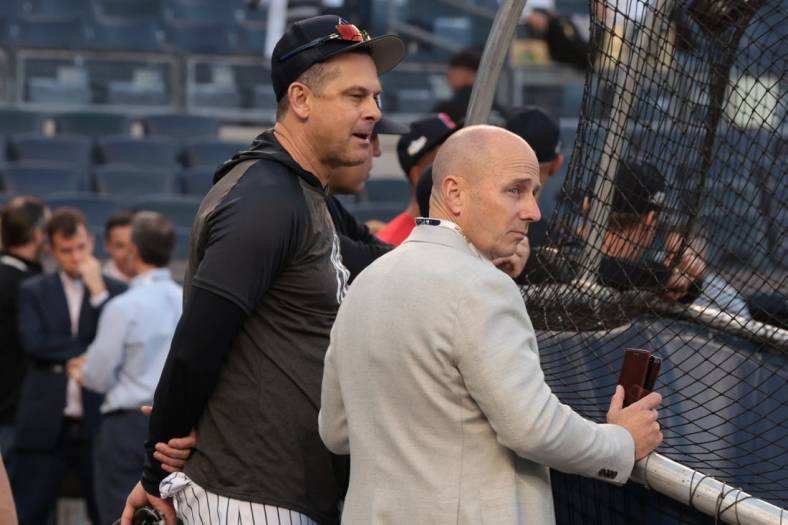 Oct 11, 2022; Bronx, New York, USA; New York Yankees manager Aaron Boone, left, and general manager Brian Cashman watch batting practice before game one of the ALDS against the Cleveland Guardians for the 2022 MLB Playoffs at Yankee Stadium. Mandatory Credit: Vincent Carchietta-USA TODAY Sports