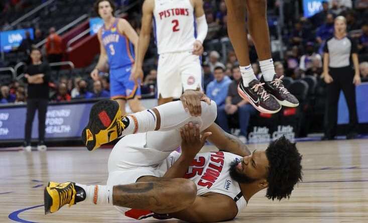 Oct 11, 2022; Detroit, Michigan, USA;  Detroit Pistons forward Marvin Bagley III (35) grabs his knee and Oklahoma City Thunder forward Jeremiah Robinson-Earl (50) dunks in the first half at Little Caesars Arena. Mandatory Credit: Rick Osentoski-USA TODAY Sports