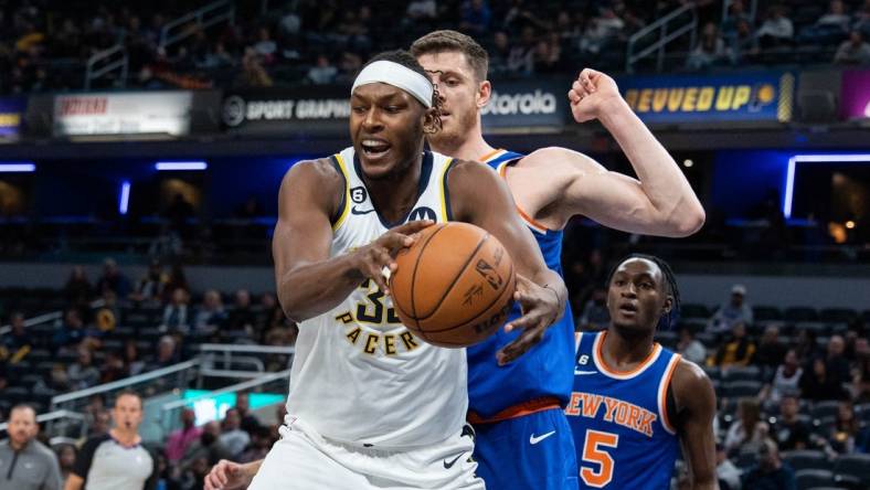 Oct 12, 2022; Indianapolis, Indiana, USA; Indiana Pacers center Myles Turner (33) rebounds the ball over New York Knicks center Isaiah Hartenstein (55) in the first half at Gainbridge Fieldhouse. Mandatory Credit: Trevor Ruszkowski-USA TODAY Sports