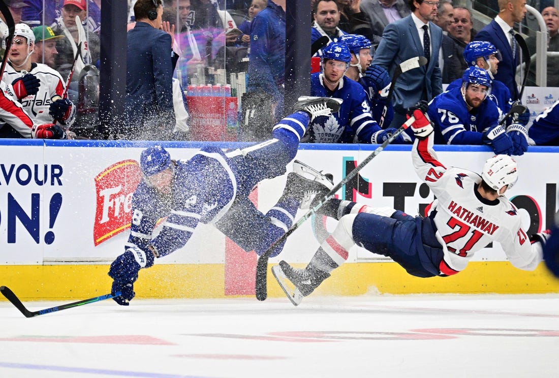 Oct 13, 2022; Toronto, Ontario, CAN;  Toronto Maple Leafs defenseman Jake Muzzin (8) collides with Washington Capitals forward Garnet Hathaway (21) in the second period at Scotiabank Arena. Mandatory Credit: Dan Hamilton-USA TODAY Sports