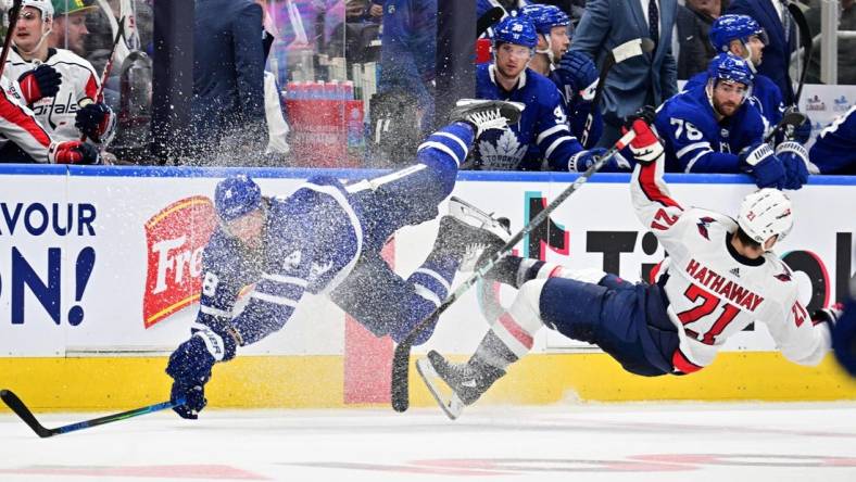 Oct 13, 2022; Toronto, Ontario, CAN;  Toronto Maple Leafs defenseman Jake Muzzin (8) collides with Washington Capitals forward Garnet Hathaway (21) in the second period at Scotiabank Arena. Mandatory Credit: Dan Hamilton-USA TODAY Sports