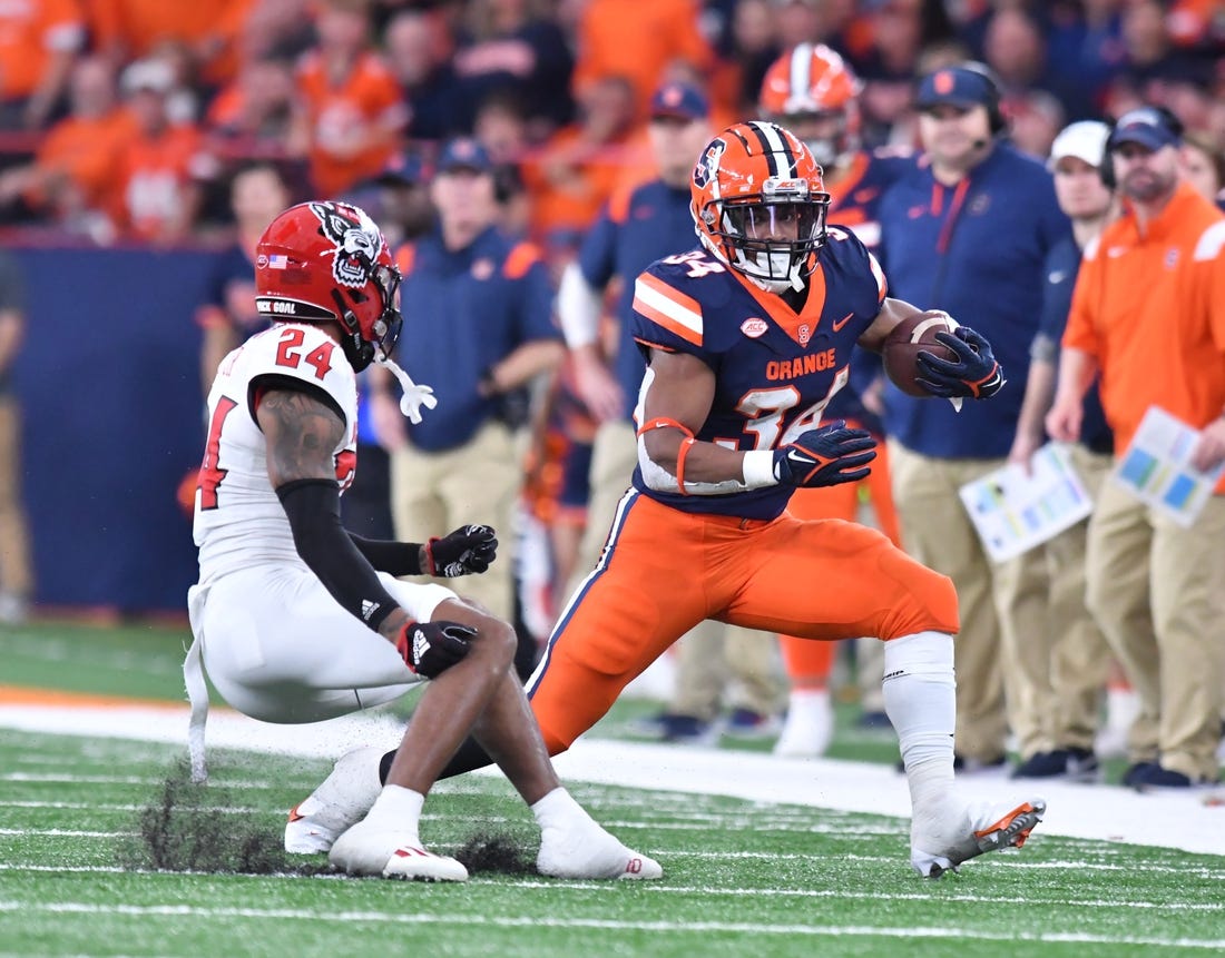 Oct 15, 2022; Syracuse, New York, USA; Syracuse Orange running back Sean Tucker (34) tries to move past North Carolina State Wolfpack cornerback Derrek Pitts Jr. (24) in the second quarter at JMA Wireless Dome. Mandatory Credit: Mark Konezny-USA TODAY Sports