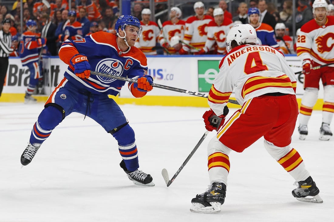 Oct 15, 2022; Edmonton, Alberta, CAN; Calgary Flames defensemen Rasmus Andersson (4) tries to block a shot by Edmonton Oilers forward Connor McDavid (97) during the third period at Rogers Place. Mandatory Credit: Perry Nelson-USA TODAY Sports