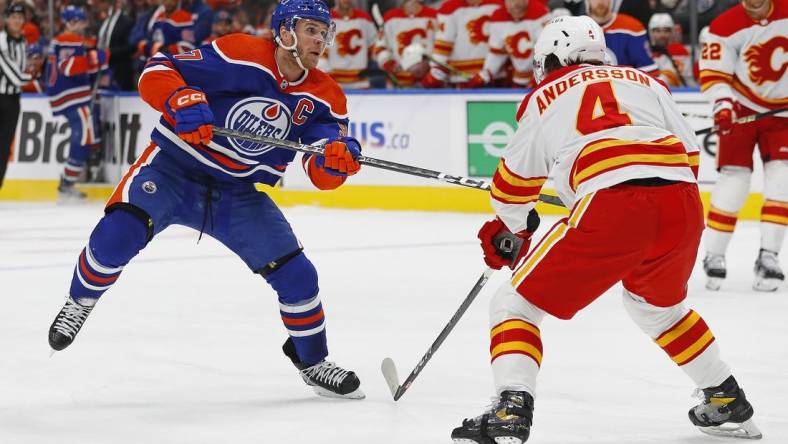 Oct 15, 2022; Edmonton, Alberta, CAN; Calgary Flames defensemen Rasmus Andersson (4) tries to block a shot by Edmonton Oilers forward Connor McDavid (97) during the third period at Rogers Place. Mandatory Credit: Perry Nelson-USA TODAY Sports