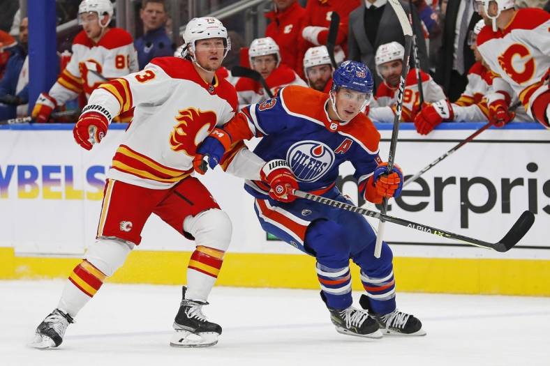 Oct 15, 2022; Edmonton, Alberta, CAN; Edmonton Oilers forward Ryan Nugent-Hopkins (93) and Calgary Flames forward Tyler Toffoli (73) chase a loose puck during the third period at Rogers Place. Mandatory Credit: Perry Nelson-USA TODAY Sports