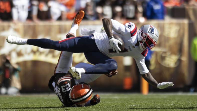 Oct 16, 2022; Cleveland, Ohio, USA; New England Patriots wide receiver DeVante Parker (1) falls over Cleveland Browns cornerback Martin Emerson Jr. (23) during the first quarter at FirstEnergy Stadium. Mandatory Credit: Scott Galvin-USA TODAY Sports
