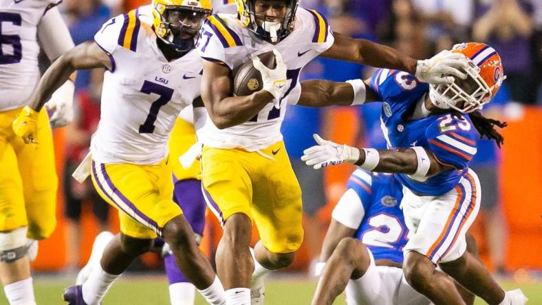 LSU Tigers running back Josh Williams (27) throws a stiff arm to Florida Gators cornerback Jaydon Hill (23) in the second half at Steve Spurrier Field at Ben Hill Griffin Stadium in Gainesville, FL on Saturday, October 15, 2022. LSU defeated the Gators 45-35. [Doug Engle/Gainesville Sun]

Ncaa Football Florida Gators Vs Lsu Tigers