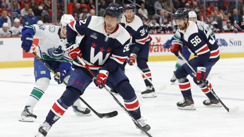 Oct 17, 2022; Washington, District of Columbia, USA; Washington Capitals center Evgeny Kuznetsov (92) skates with the puck as Vancouver Canucks center Elias Pettersson (40) chases in the first period at Capital One Arena. Mandatory Credit: Geoff Burke-USA TODAY Sports